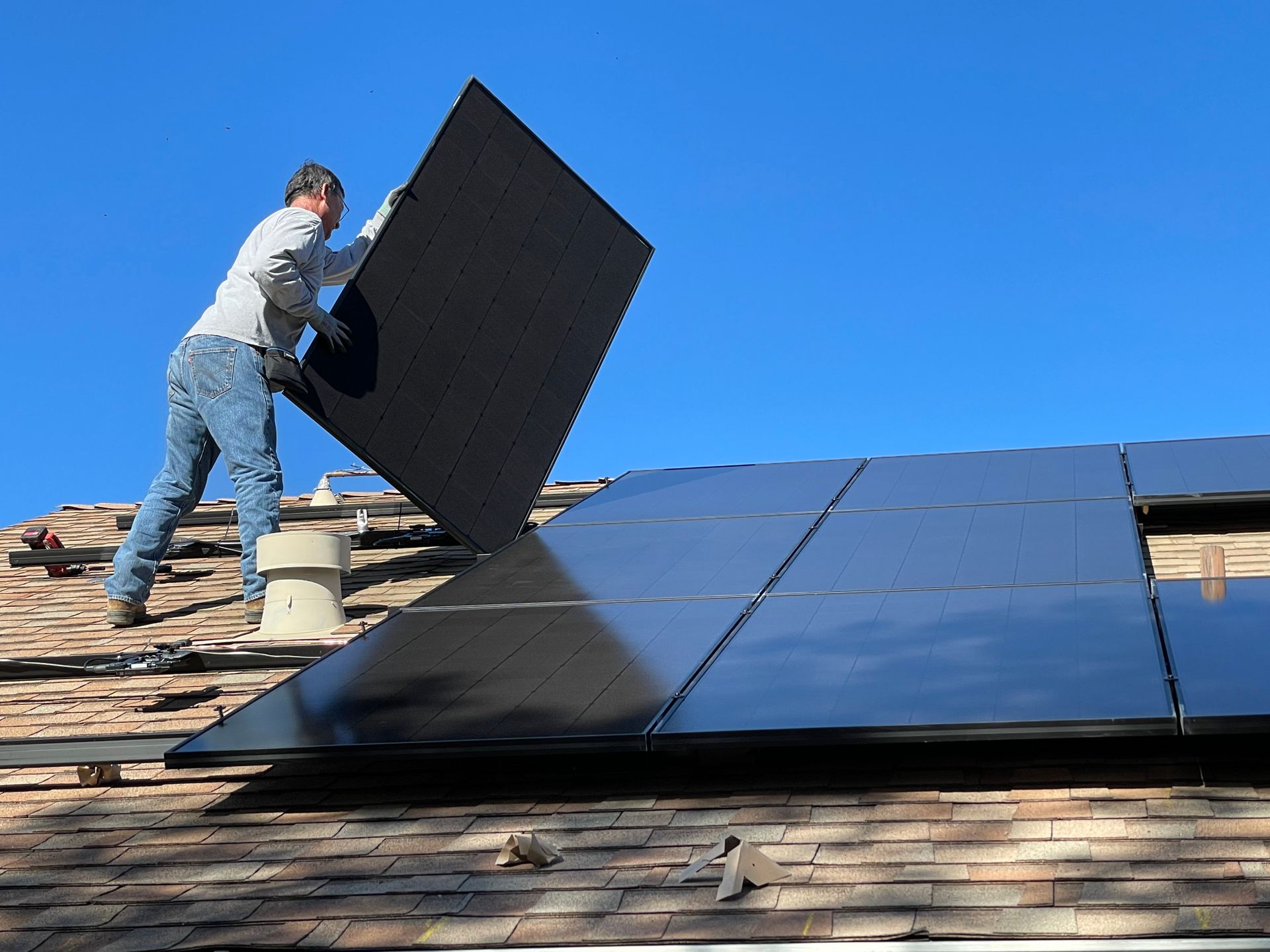 Installateur bringt PV-Panel auf dem Dach an